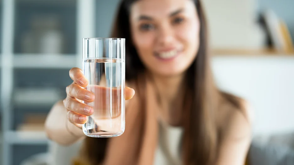 a woman holds a glass of water