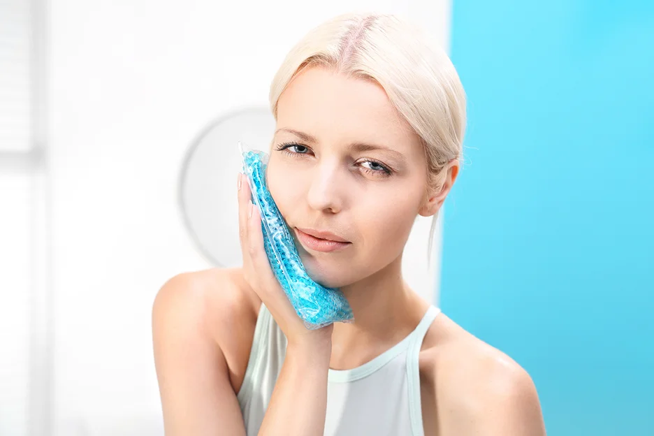 a woman applying cold compress on her face